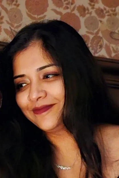 A woman with long black hair smiling for the camera.