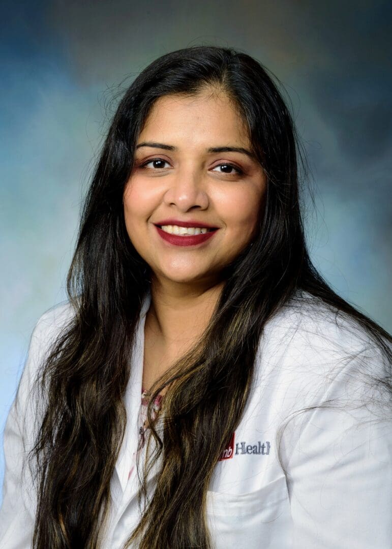 A woman in white lab coat smiling for the camera.