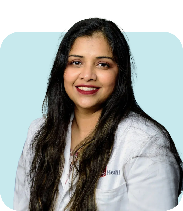 A woman in white lab coat smiling for the camera.