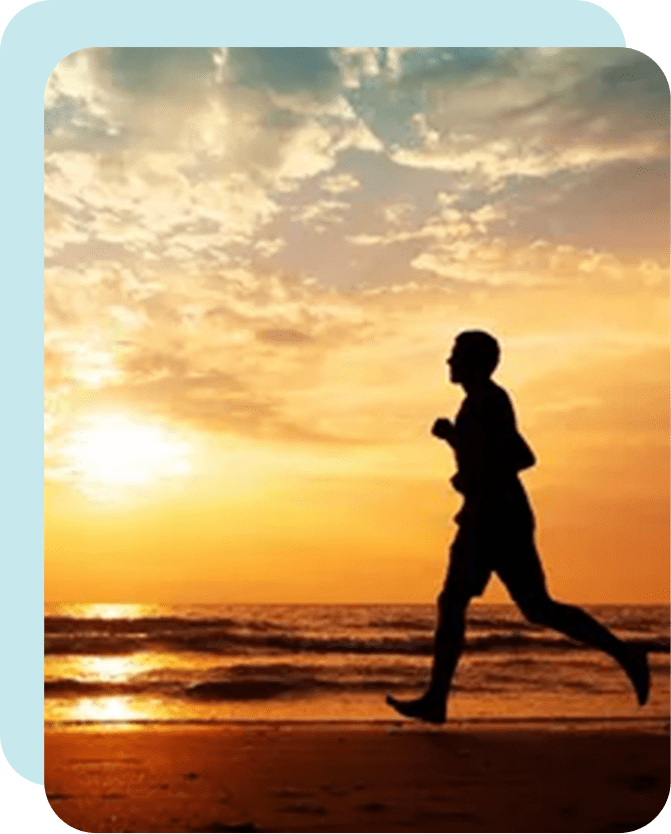 A man running on the beach at sunset