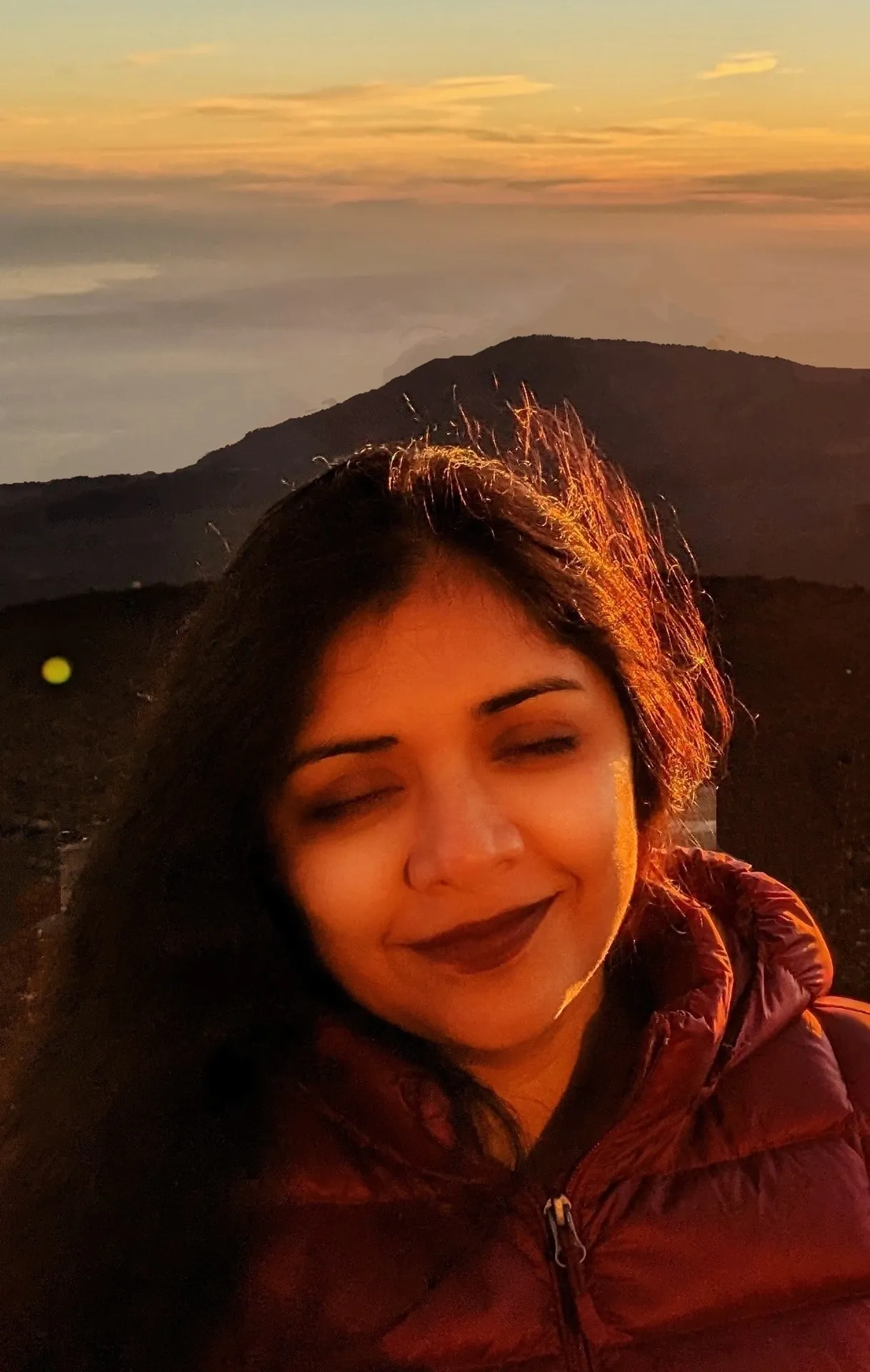 A woman with long hair is smiling at the camera.