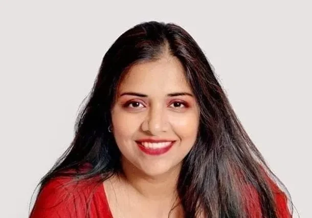 A woman in red shirt smiling for the camera.