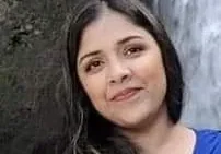 A woman standing in front of a waterfall.